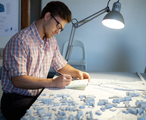 Arquitecto trabajando en mesa de dibujo en estudio de arquitecto . — Foto de Stock