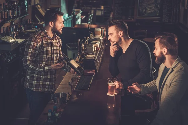 Друзі п'ють пиво на барній стійці в пабі . — стокове фото