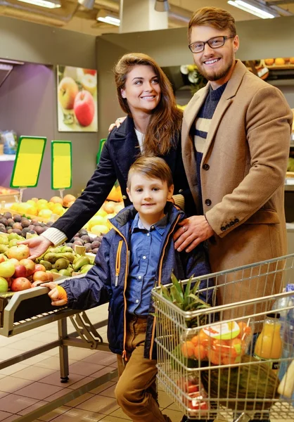 Молодая семья в продуктовом магазине — стоковое фото