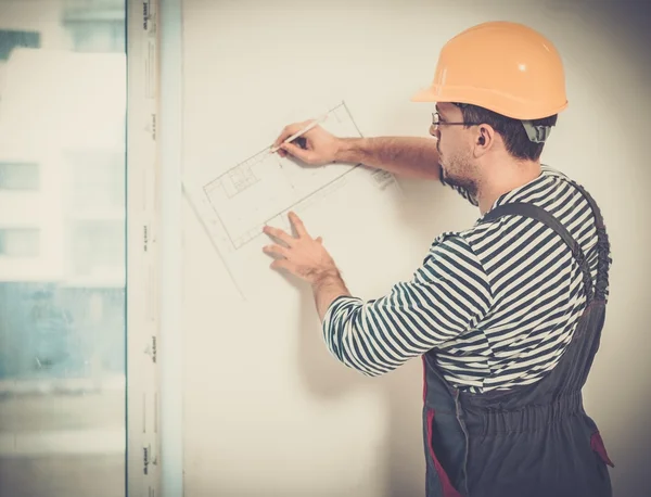 Contremaître avec plan de construction dans l'intérieur du nouveau bâtiment — Photo