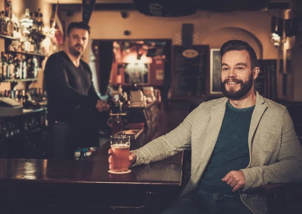 Amici che bevono birra alla spina al bancone del bar nel pub . — Foto Stock
