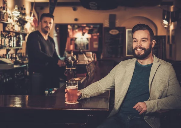 Friends drinking draft beer at bar counter in pub. — Stock Photo, Image