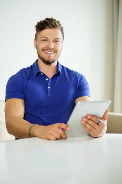 Przystojny mężczyzna w domu przy użyciu komputera typu tablet — Zdjęcie stockowe