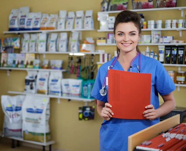 Retrato de hermosa enfermera con carpeta en clínica veterinaria . — Foto de Stock