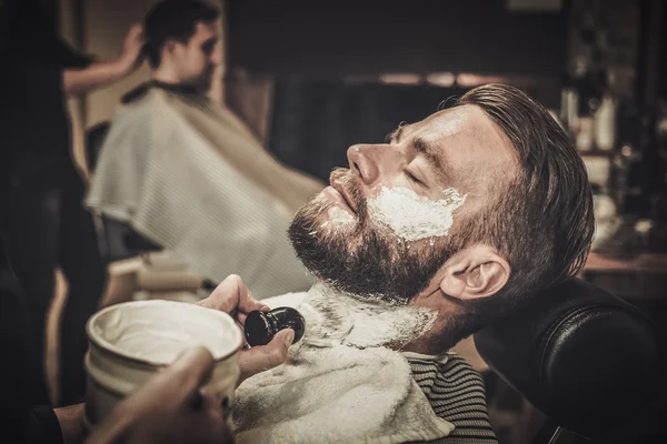 Cliente durante rasatura di barba in negozio di barbiere — Foto Stock