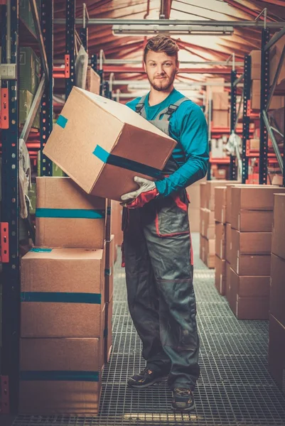 Porter uitvoering van vakken in een magazijn — Stockfoto