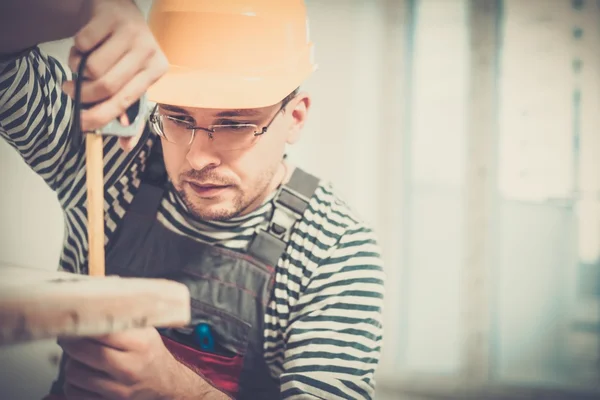 Workman measuring bathtub in new apartment interior — Stock Photo, Image