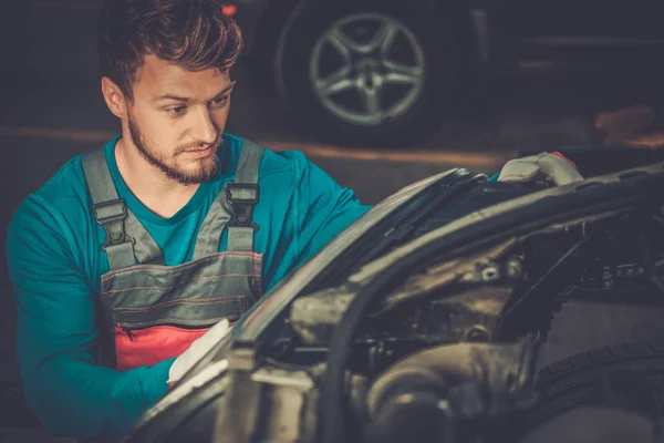 Meccanico con fari auto nuovi in officina — Foto Stock