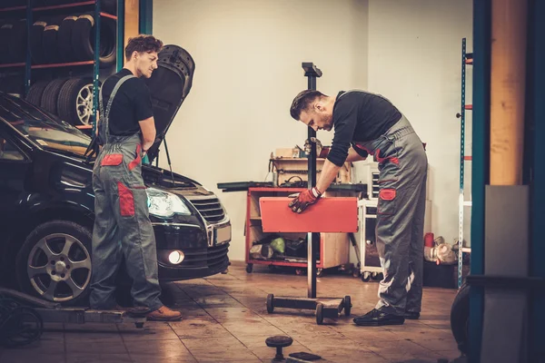 Mecânica do carro profissional que inspeciona a lâmpada do farol do automóvel — Fotografia de Stock