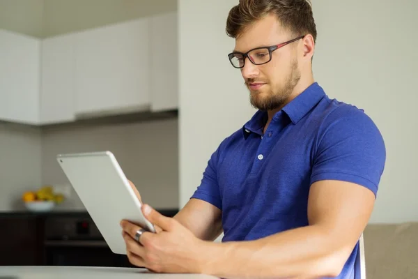 Przystojny mężczyzna w domu przy użyciu komputera typu tablet — Zdjęcie stockowe