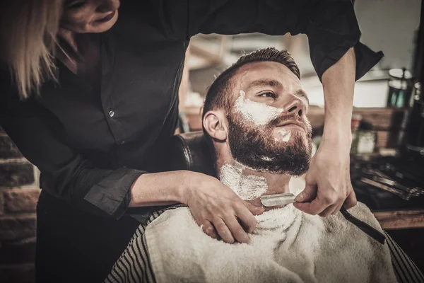 Cliente durante barba barbeação na barbearia — Fotografia de Stock