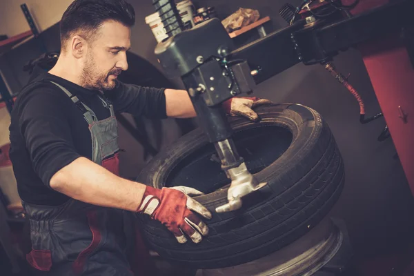 Auto monteur vervangen band op het wiel in auto reparatie — Stockfoto