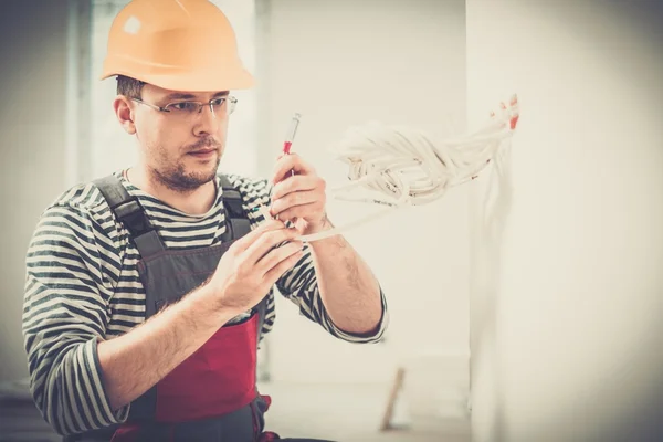 Electricien travaillant avec des fils dans un nouvel appartement — Photo