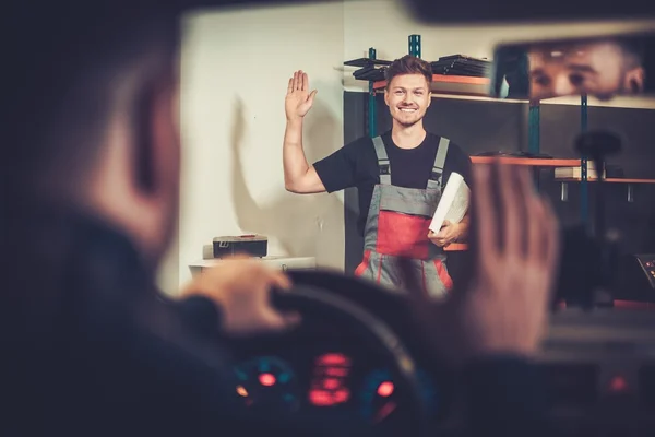 Berufskraftfahrzeugmechaniker begrüßt neuen Kunden in seinem Autoreparaturservice. — Stockfoto