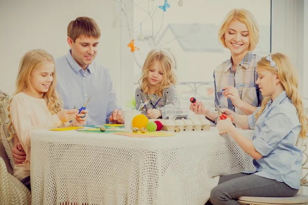 Familia que se divierte pintando y decorando huevos de Pascua . — Foto de Stock