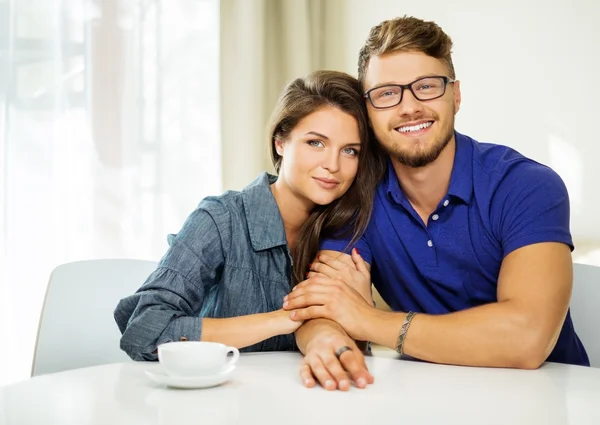 Cheerful couple behind table at home — Stock Photo, Image