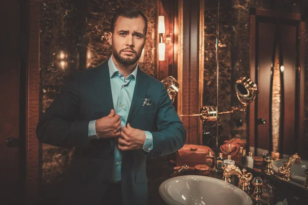 Homme confiant bien habillé dans l'intérieur de la salle de bain de luxe . — Photo