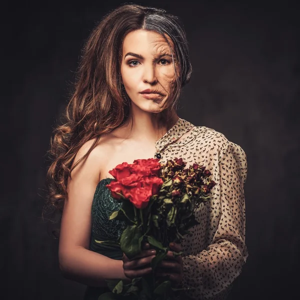 Aging and skin care concept. Half old half young woman with bouquet of red roses. — Stock Photo, Image