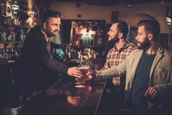 Amis boire de la bière pression au comptoir du bar au pub . — Photo