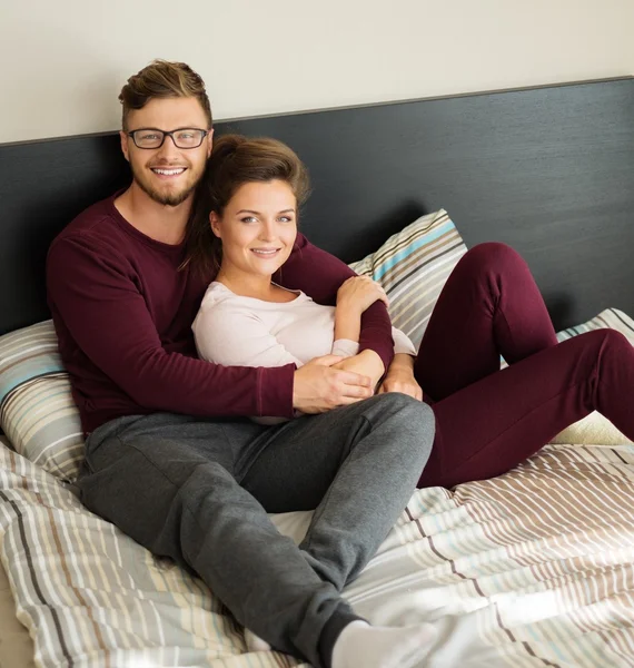 Veselý pár na posteli doma — Stock fotografie