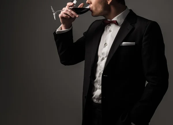 Ostre ubrany człowiek sobie kurtkę i muszka ze szkła o winorośli — Zdjęcie stockowe