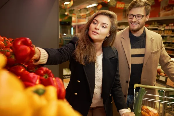 Pareja eligiendo verduras en una tienda de comestibles — Foto de Stock