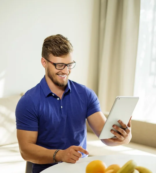 Schöner Mann mit Tablet-PC zu Hause — Stockfoto