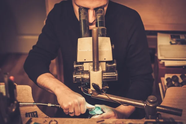 Juwelier betrachtet Ring in Werkstatt unter dem Mikroskop. — Stockfoto