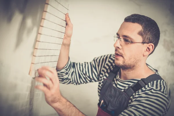 Builder applying tile on a wall — Stock Photo, Image