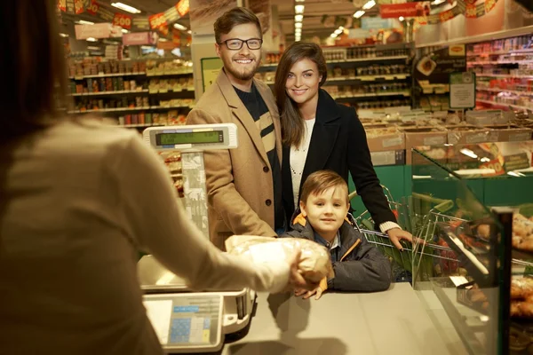 Family buying bread in a grocery store — Stock Photo, Image