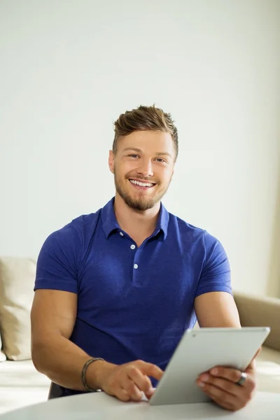 Bonito homem usando tablet pc em casa — Fotografia de Stock