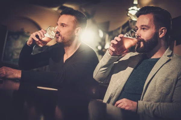 Amigos bebendo cerveja rascunho no bar balcão no pub . — Fotografia de Stock