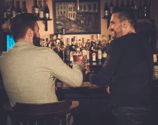 Przyjaciele pić piwo w barze licznika w pubie. — Zdjęcie stockowe
