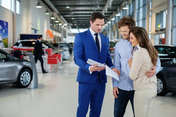 Salesman talking to a young couple — Stock Photo, Image