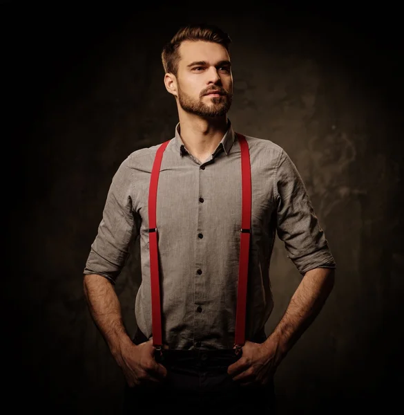 Jovem homem bonito com barba vestindo suspensórios — Fotografia de Stock