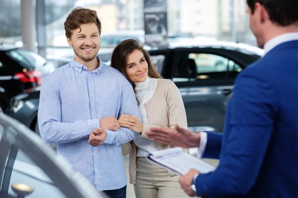 Vendedor hablando con una pareja joven — Foto de Stock