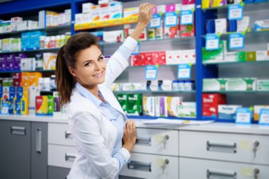 woman pharmacist doing his work in pharmacy. clipart