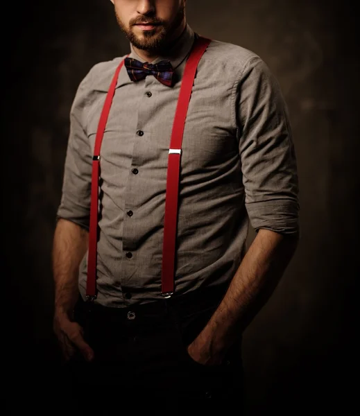 Молодой красивый мужчина с бородой носит подтяжки — стоковое фото