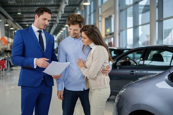 Salesman talking to a young couple — Stock Photo, Image