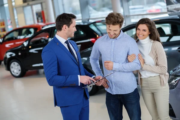 Salesman talking to a young couple — Stock Photo, Image