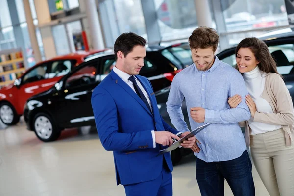 Salesman talking to a young couple — Stock Photo, Image