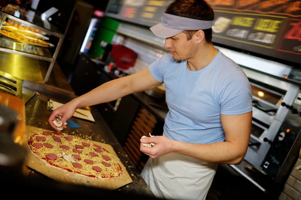 Pizzaiolo haciendo pizza en la cocina en la pizzería . —  Fotos de Stock