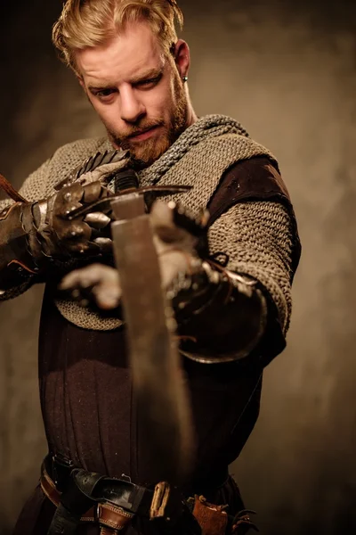 Молодий середньовічний лицар позує на темному тлі . — стокове фото