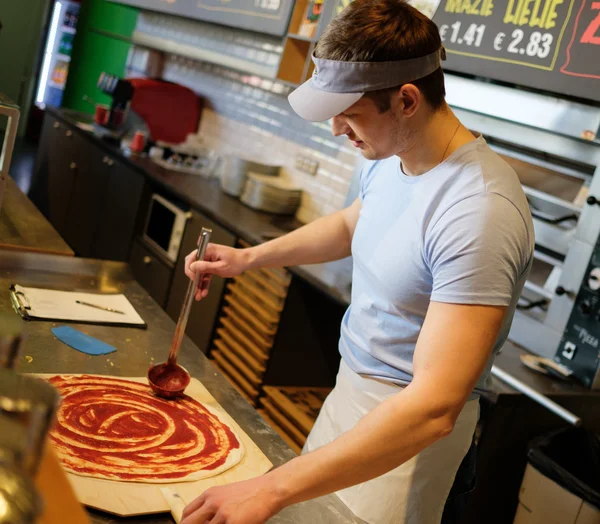 Pizzaiolo fazendo pizza na cozinha na pizzaria . — Fotografia de Stock