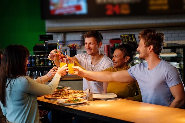 Multirassische Freunde haben Spaß beim Pizza essen in der Pizzeria. — Stockfoto