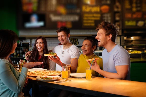 多种族的朋友开心在比萨店吃披萨. — 图库照片