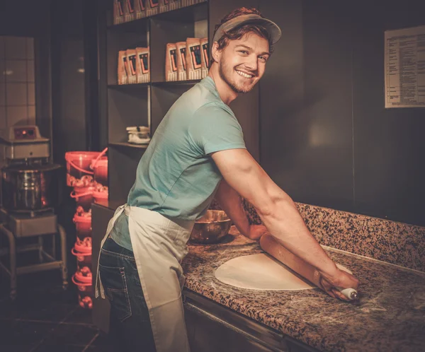 Belle pâte à rouler pizzaiolo avec rouleau à pâtisserie . — Photo