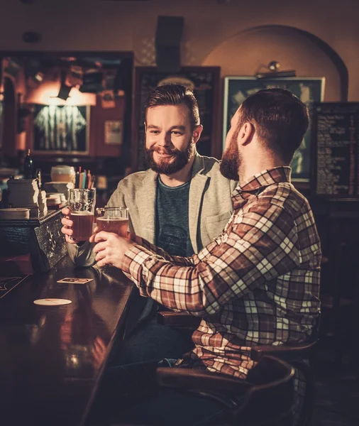 Allegro vecchi amici che bevono birra alla spina al bancone del bar in pub . — Foto Stock