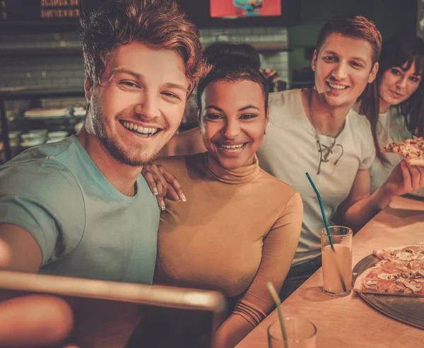 Multiracial friends having fun eating pizza in pizzeria. — Stock Photo, Image