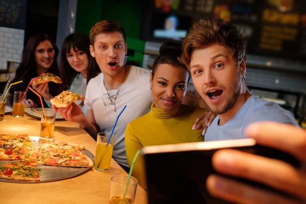 Multiraciale vrienden plezier pizza eten in pizzeria. — Stockfoto